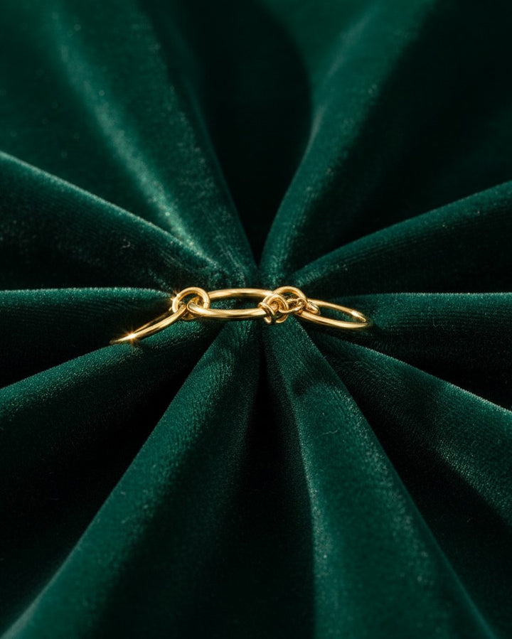 Elli Jewellery gold plated multilayer stacked ring on a dark green velvet background