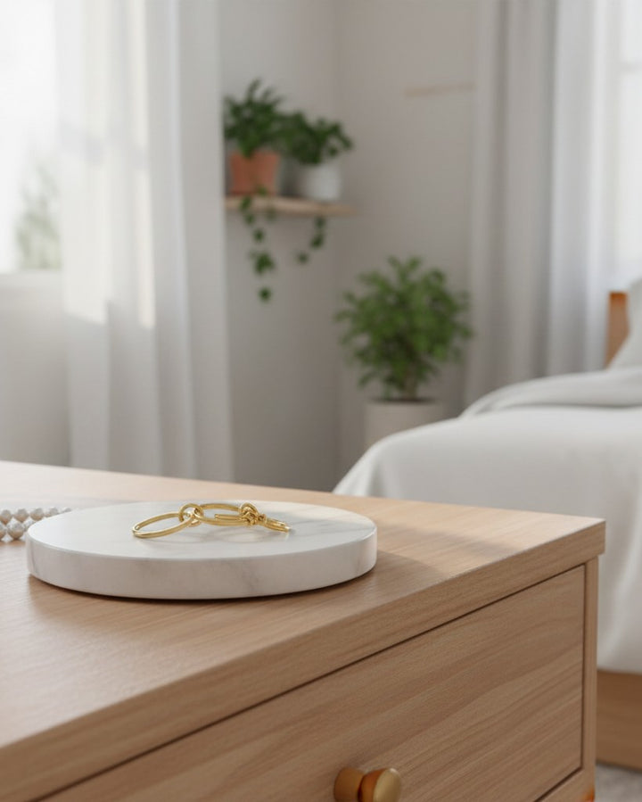 Elli Jewellery gold plated multilayer stacked ring set resting on a white marble display tray in a bright bedroom.