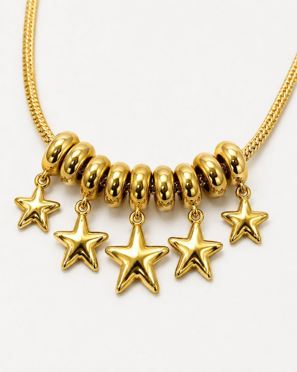 Elli Jewellery gold plated necklace featuring a cluster of rondelle beads and five polished star charms on a chain.