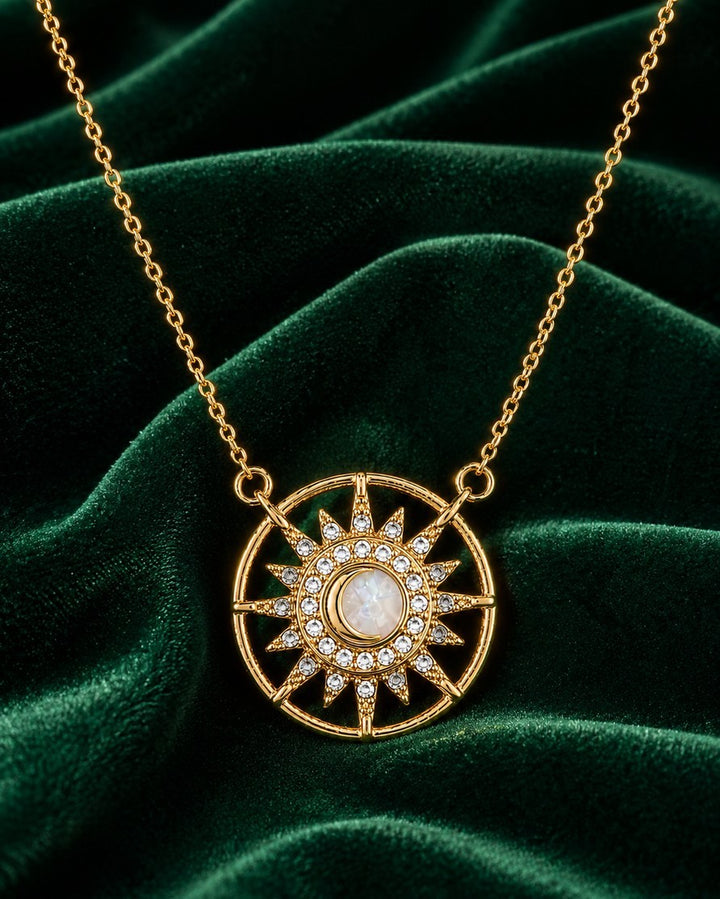 Elli Jewellery gold plated starburst medallion pendant necklace with a cream cabochon and clear crystal accents.