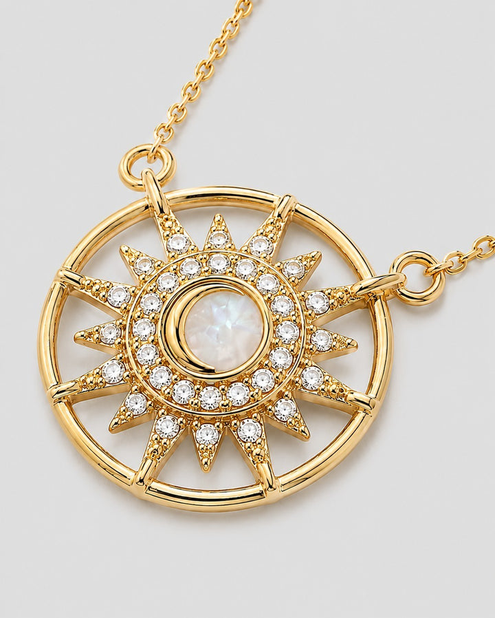 Elli Jewellery gold plated starburst medallion pendant with a cream cabochon center and sparkling crystal rays.