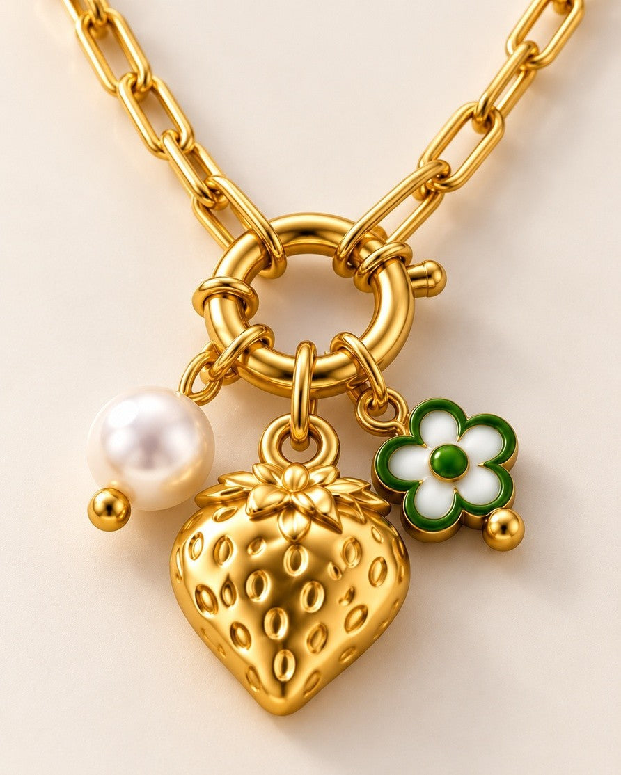 Elli Jewellery gold plated necklace featuring a strawberry charm, white pearl, and green flower pendant on a chain.