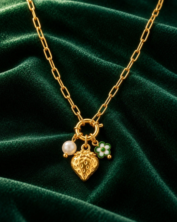 Elli Jewellery gold plated necklace featuring a strawberry charm, a small white flower, and a pearl on a link chain.