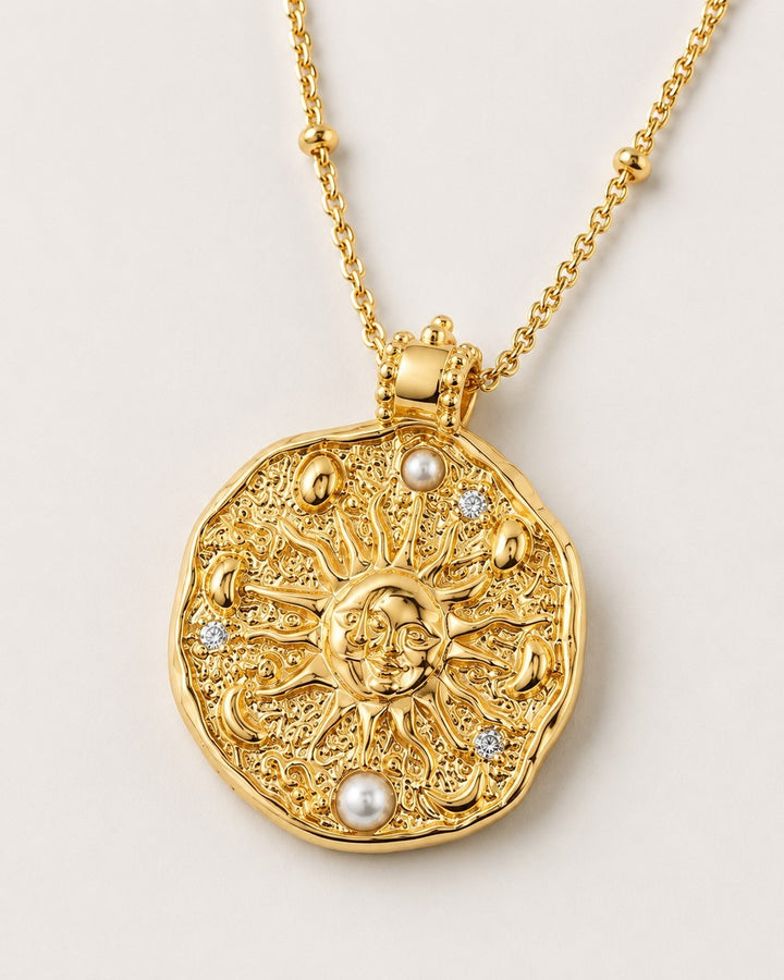 Elli Jewellery celestial sun medallion necklace in 18ct gold plate with pearl accents and crystals on a beaded chain.