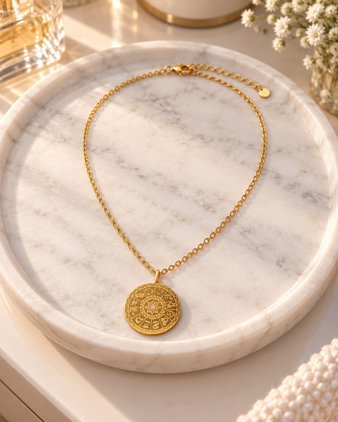 Elli Jewellery gold plated celestial sundial coin pendant necklace resting on a white marble tray