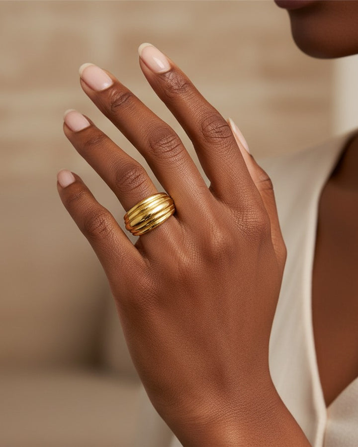Elli Jewellery gold plated minimalist band ring with a textured linear design worn on a woman's finger.