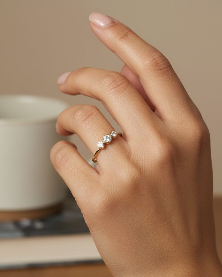 Elli Jewellery gold plated trilogy ring with three sparkling cubic zirconia stones worn on a finger