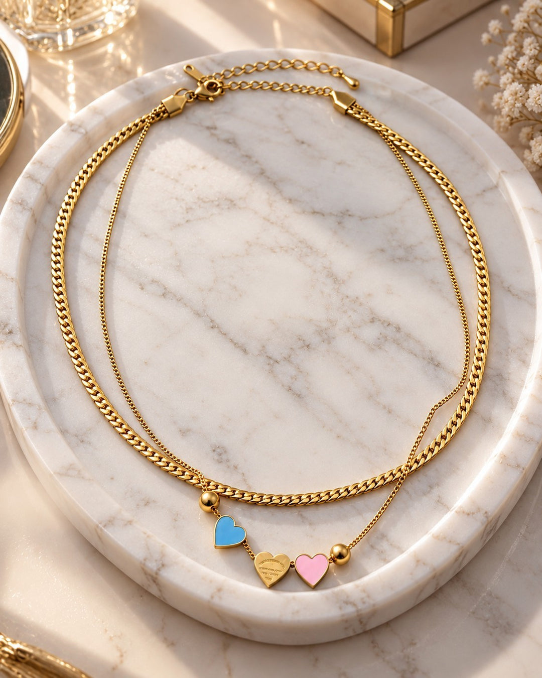 Elli Jewellery gold plated layered chain necklace featuring three dainty heart charms in blue, gold, and pink enamel.