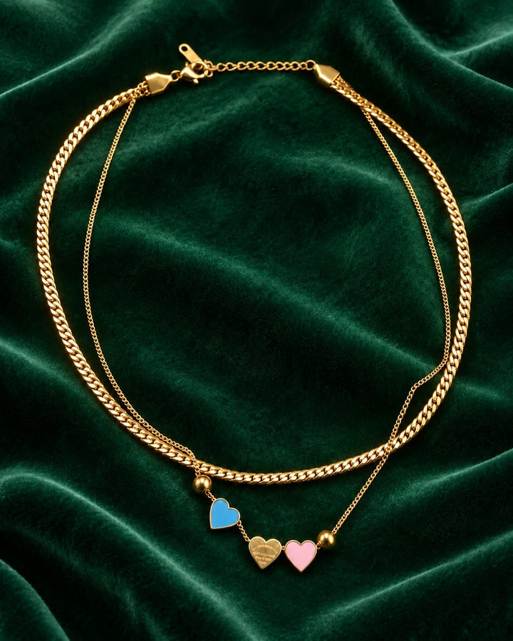 Elli Jewellery gold plated layered chain necklace featuring three delicate heart charms in blue, gold, and pink.