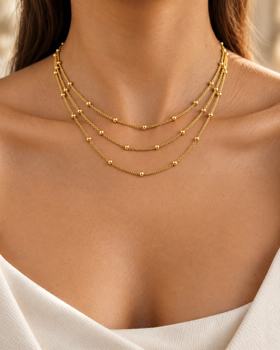 Elli Jewellery gold plated triple layered chain necklace with delicate bead details worn by a woman