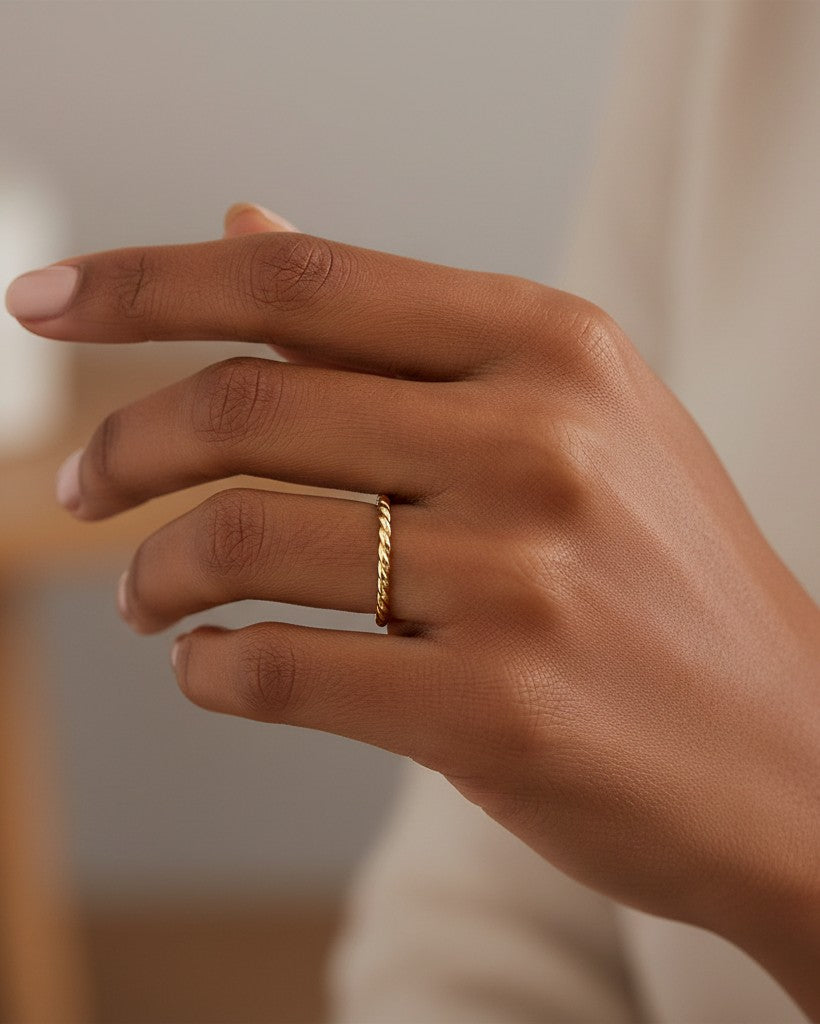 Elli Jewellery gold plated twisted band ring worn on a finger, featuring a minimalist and elegant design.