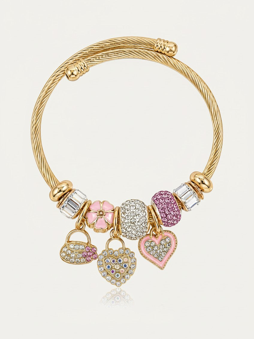 Elli Jewellery gold plated twisted cuff bracelet with dangling heart charms, pink enamel, and crystal accents.