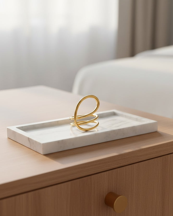 Elli Jewellery gold-toned twisted dome statement ring resting on a white marble tray on a wooden surface.