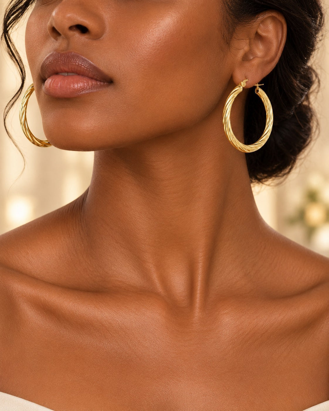 Elli Jewellery 41mm gold twisted hoop earrings worn by a model with an elegant updo