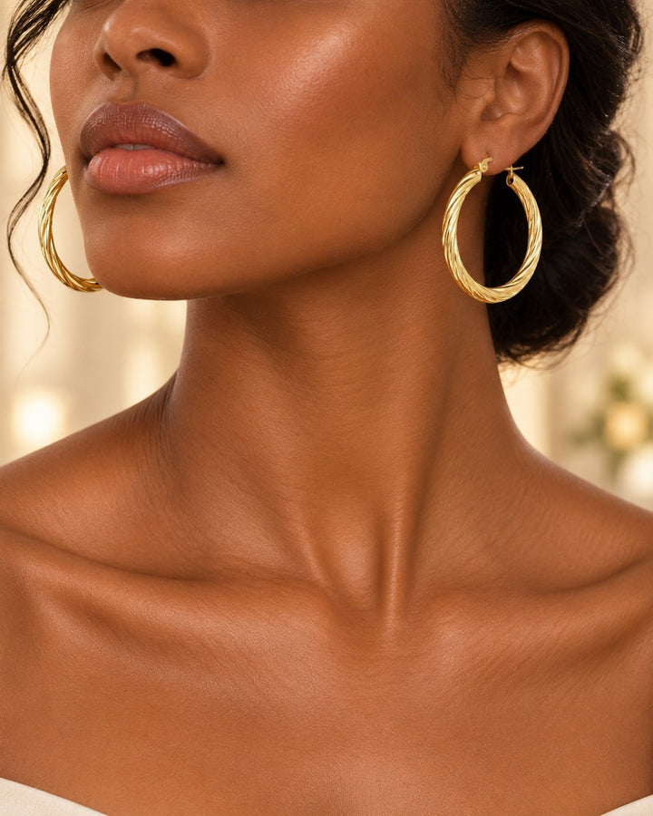 Elli Jewellery 41mm gold twisted hoop earrings worn by a model with an elegant updo