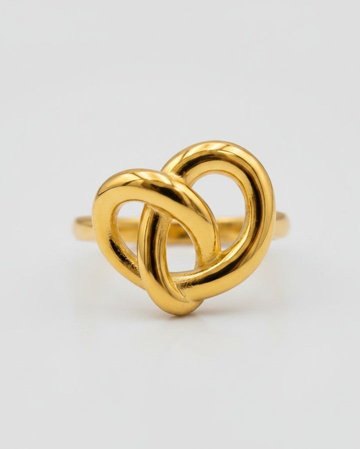 Elli Jewellery gold plated statement ring featuring a sculptural twisted knot design on a clean white background