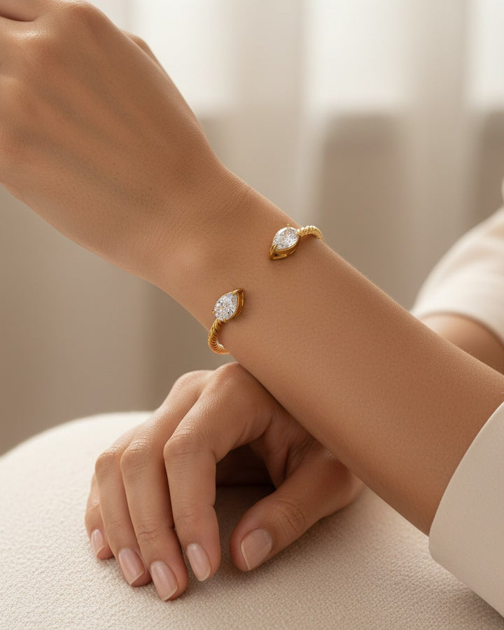 Elli Jewellery gold plated twisted rope cuff bracelet with marquise-cut stones worn on a woman's wrist