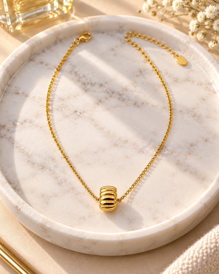 Elli Jewellery gold plated necklace featuring a sculptural oval tyre link pendant on a delicate chain on a marble tray