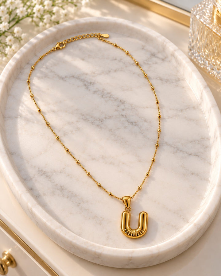Elli Jewellery gold plated waterproof necklace featuring a chunky U initial pendant on a delicate beaded chain