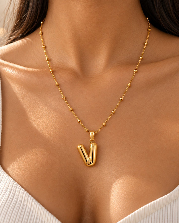 Elli Jewellery gold plated chunky V pendant necklace with beaded chain worn on a model