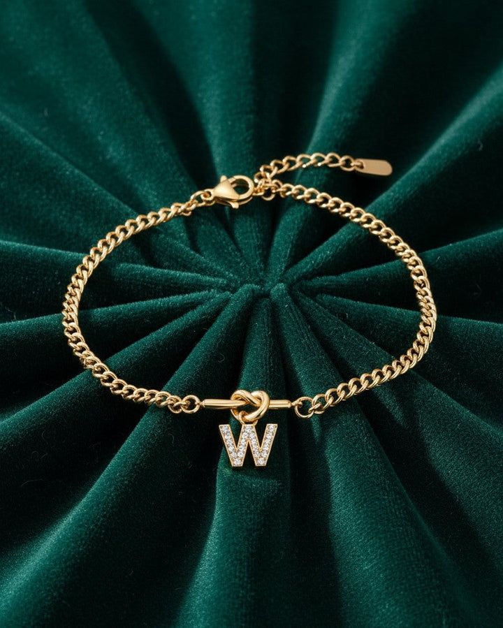 Elli Jewellery gold plated waterproof chain bracelet with a sparkling diamante W initial charm on green velvet