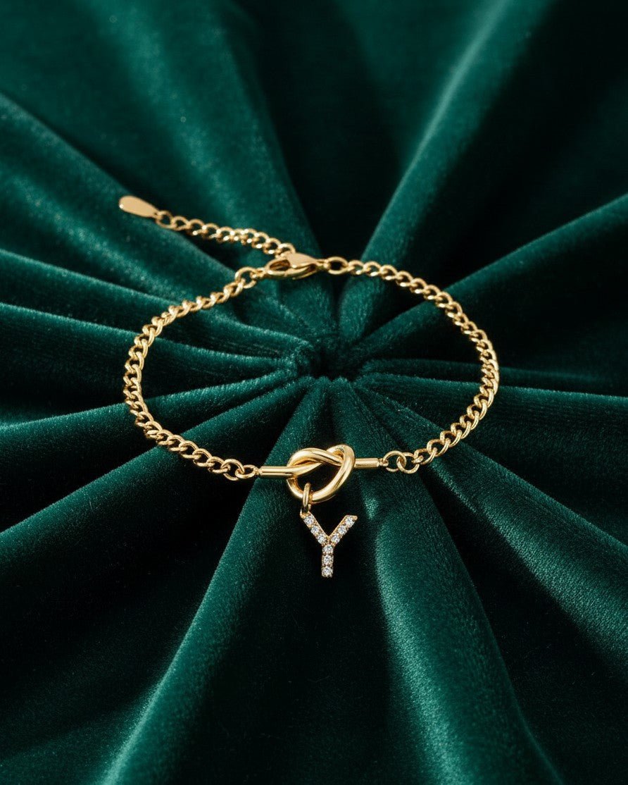 Elli Jewellery gold plated chain bracelet featuring a sparkling crystal-encrusted Y initial charm on green velvet.