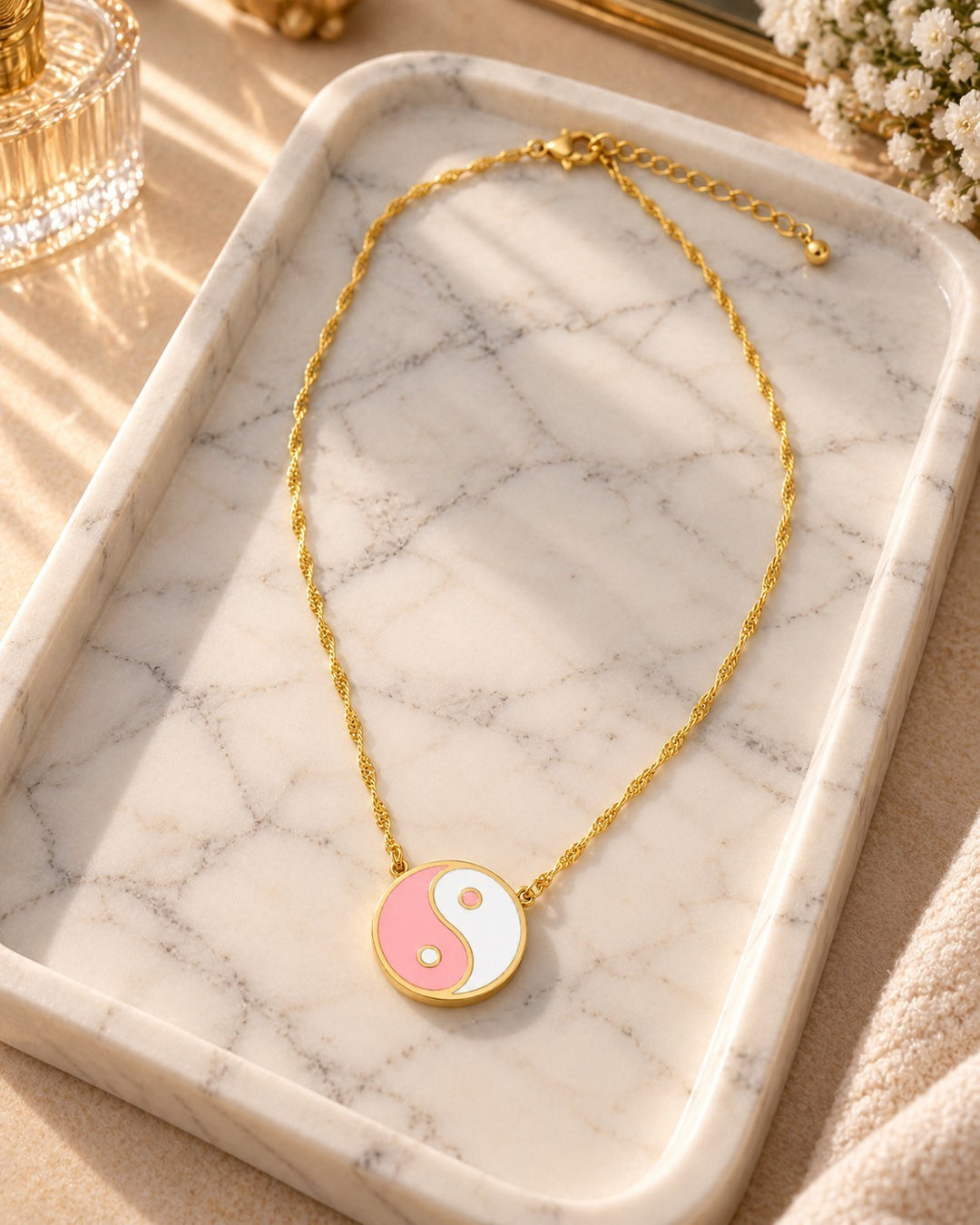 Elli Jewellery gold plated necklace featuring a pink and white enamel yin yang pendant on a delicate twisted chain.