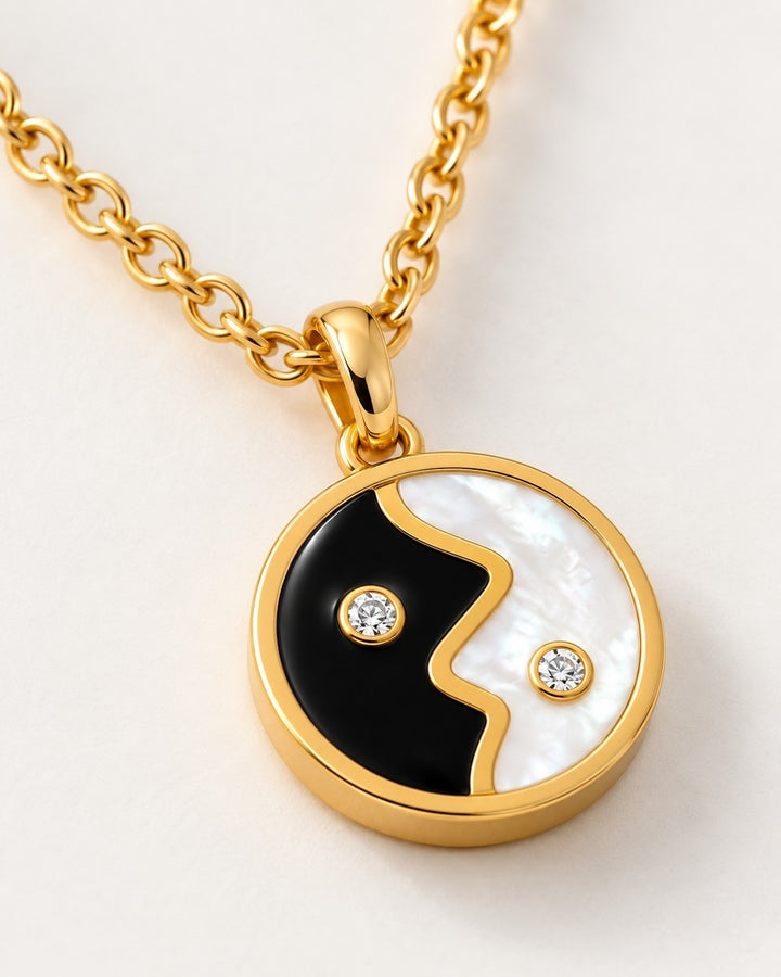 Elli Jewellery gold plated yin yang pendant necklace with black enamel, mother of pearl, and two small crystal accents