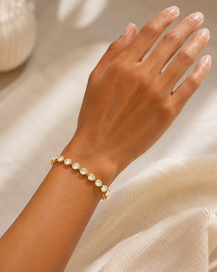 Elli Jewellery gold plated tennis bracelet featuring round-cut clear zirconia stones on a model's wrist