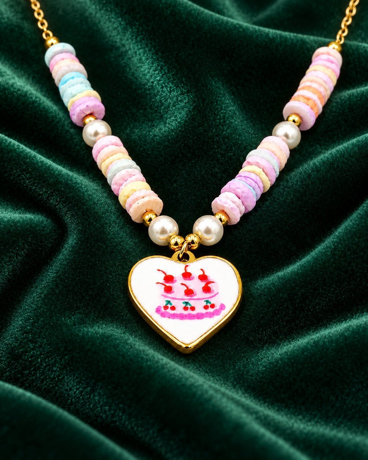 Elli Jewellery gold plated necklace featuring a heart charm with cake illustration and pastel beaded chain