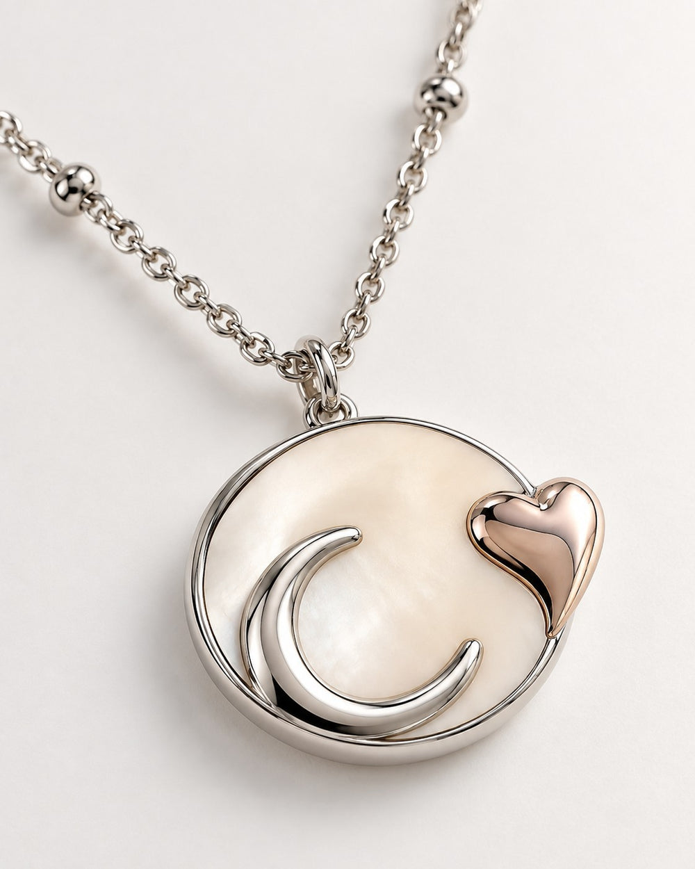Elli Jewellery rhodium plated necklace featuring a mother of pearl disc with a silver moon and rose gold heart charm.