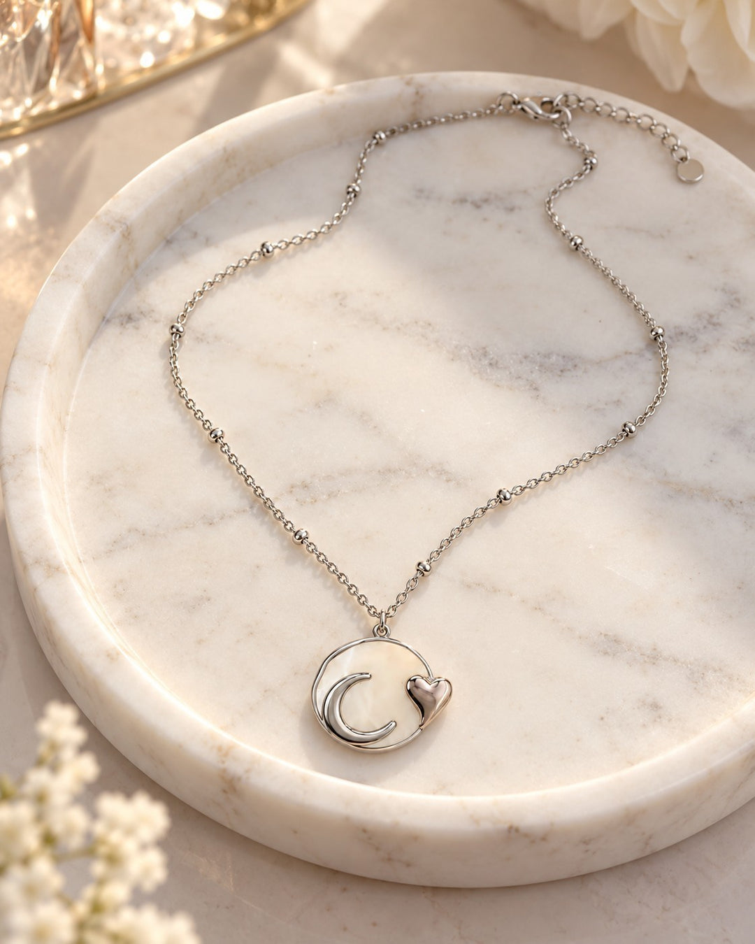 Elli Jewellery rhodium plated necklace featuring a mother of pearl moon and heart pendant on a delicate beaded chain.