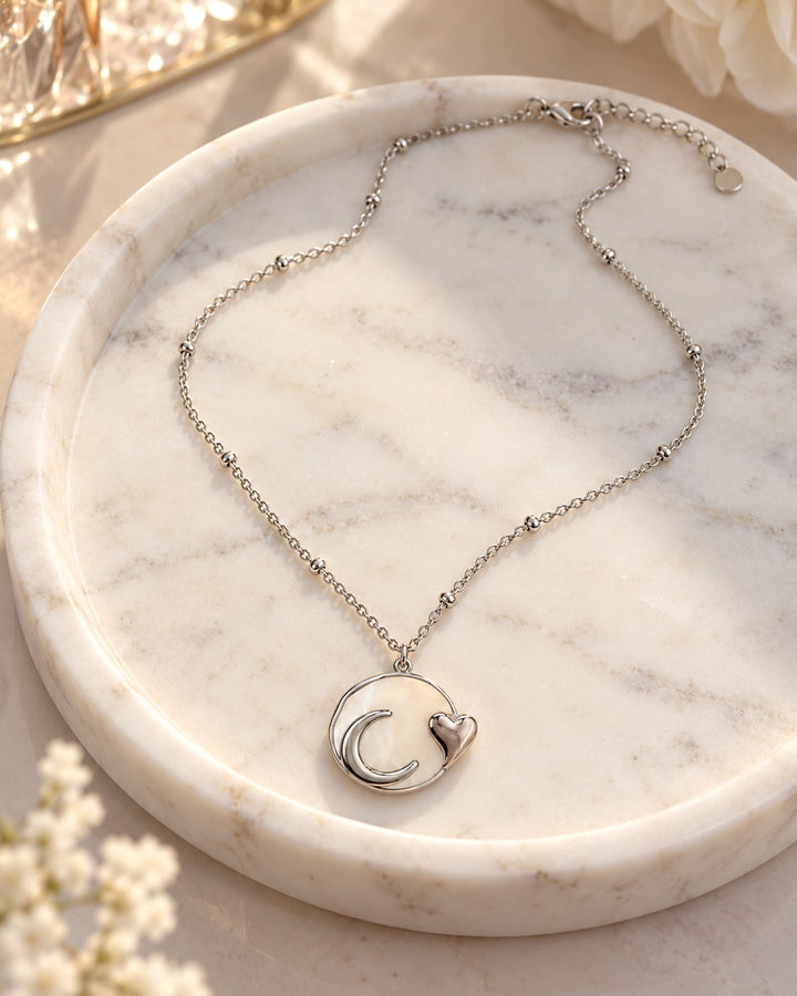 Elli Jewellery rhodium plated necklace featuring a mother of pearl moon and heart pendant on a delicate beaded chain.