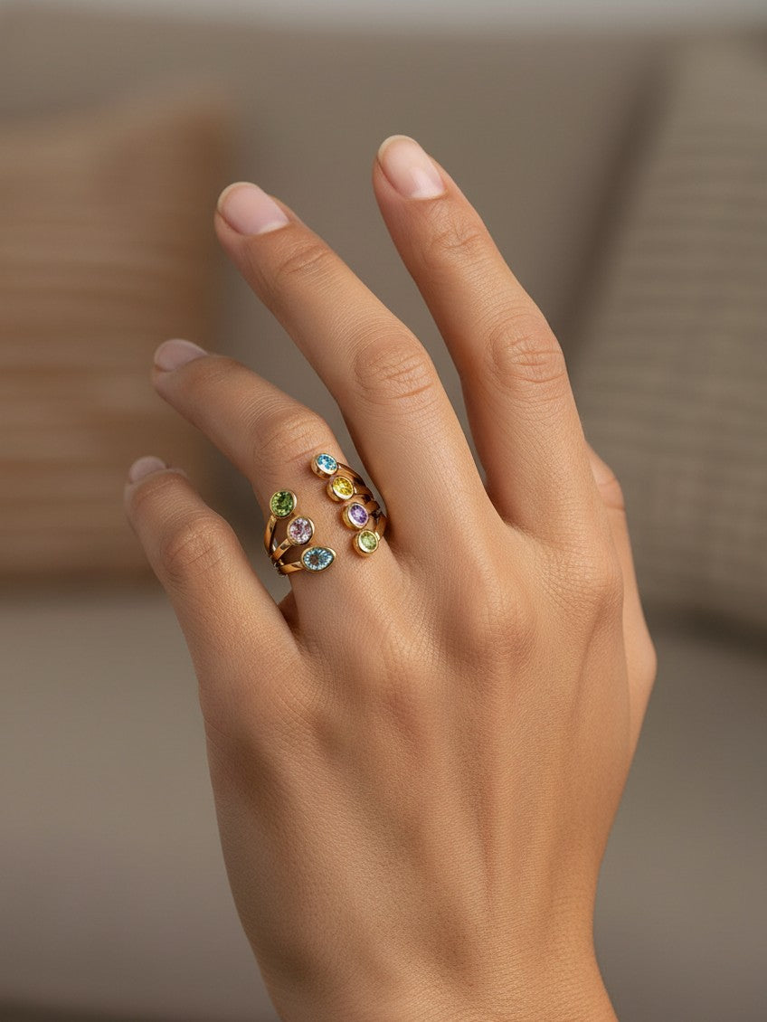 Elli Jewellery gold plated statement ring featuring seven vibrant bezel-set crystals on a sculptural spiral band.