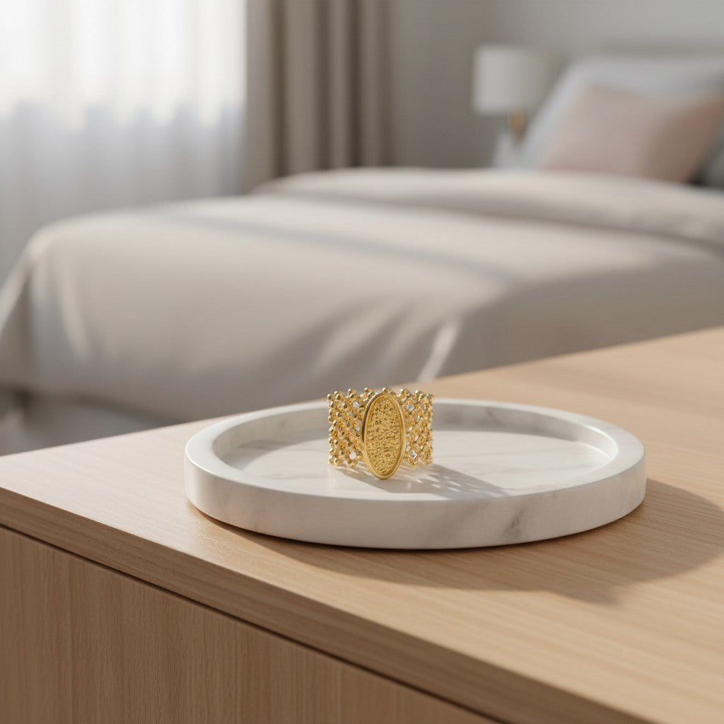 Elli Jewellery oval granulated gold plated statement ring with mesh band detail resting on a white marble tray.