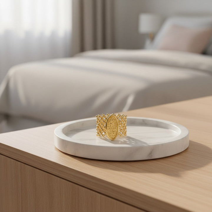 Elli Jewellery oval granulated gold plated statement ring with mesh band detail resting on a white marble tray.