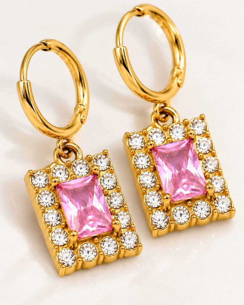 Elli Jewellery gold plated huggie hoop earrings featuring a rectangular pink cubic zirconia stone with clear crystals.