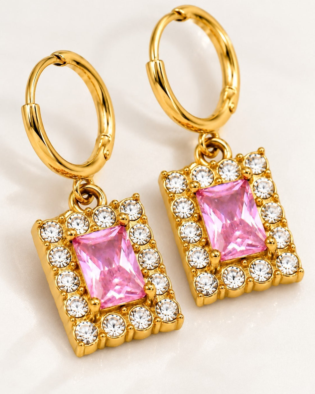 Elli Jewellery gold plated huggie hoop earrings featuring a rectangular pink cubic zirconia stone with clear crystals.