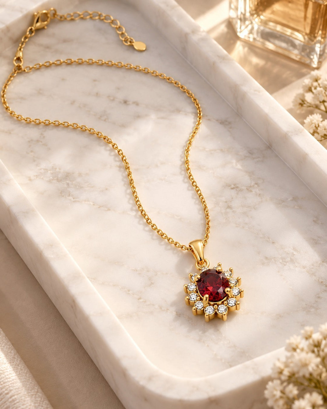 Elli Jewellery gold-plated necklace featuring a vibrant red crystal surrounded by sparkling diamante stones.