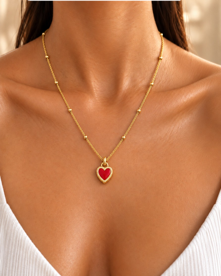 Elli Jewellery gold plated necklace featuring a vibrant red enamel heart pendant on a delicate beaded chain.