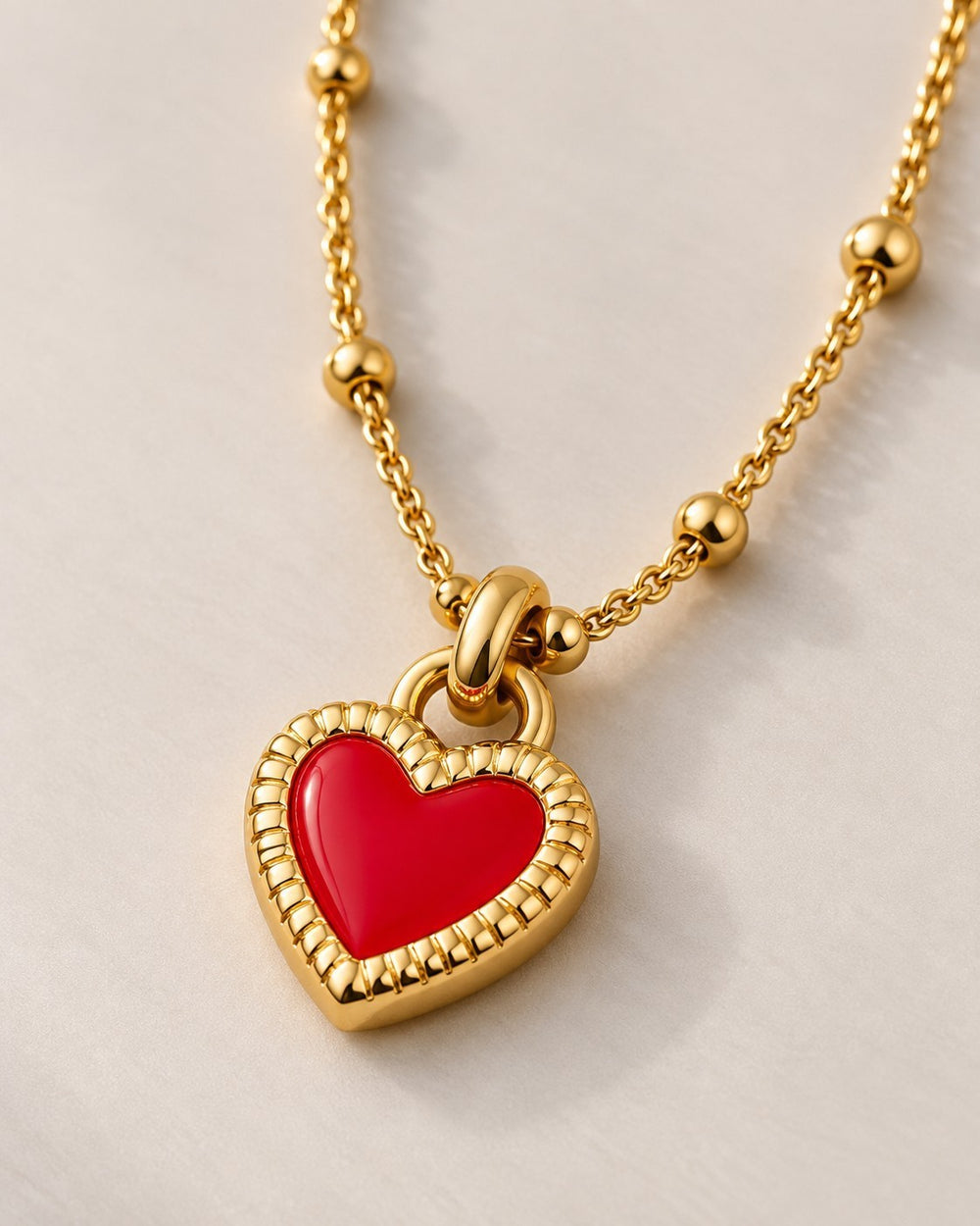 Elli Jewellery gold plated necklace featuring a vibrant red enamel heart pendant on a delicate beaded chain