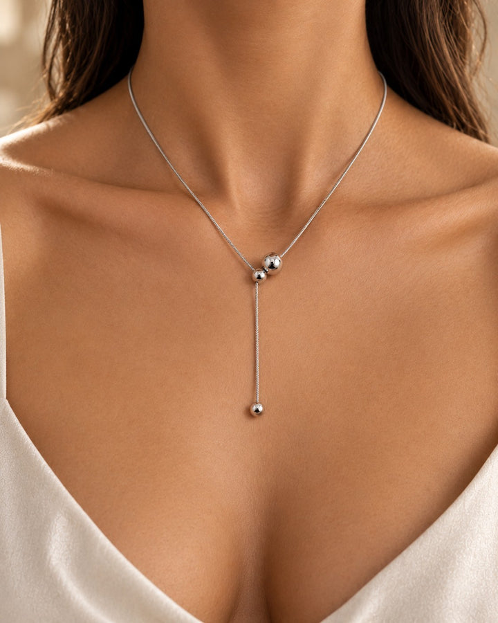Elli Jewellery rhodium plated waterproof ball chain necklace worn by a woman, featuring a sleek lariat style design.