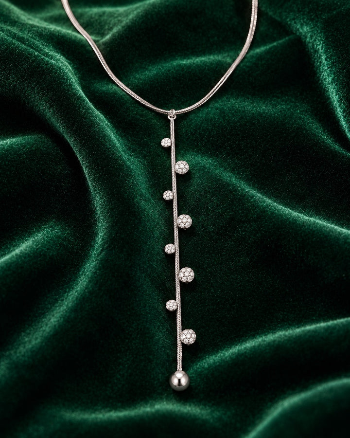 Elli Jewellery rhodium plated minimalist chain necklace featuring delicate crystal accents on a dark green velvet base