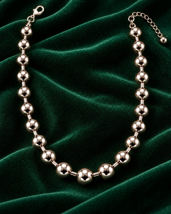 Elli Jewellery rhodium plated chunky ball chain necklace with a high-shine finish on a dark green velvet background.