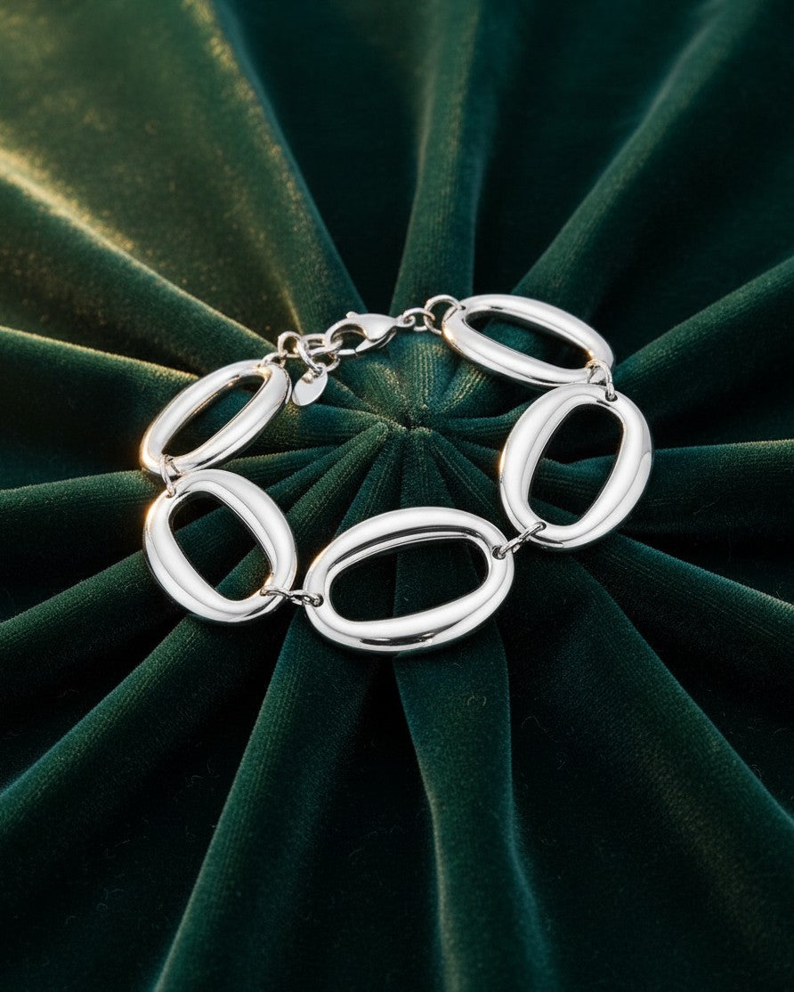 Elli Jewellery rhodium plated chunky chain link bracelet with oval links on a dark green velvet background