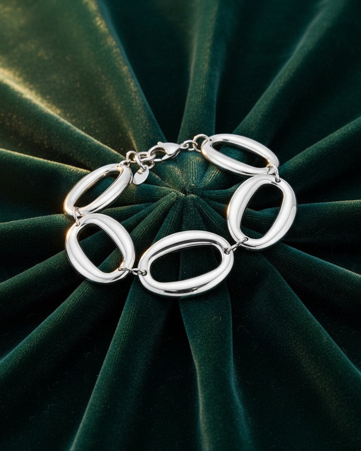 Elli Jewellery rhodium plated chunky chain link bracelet with oval links on a dark green velvet background