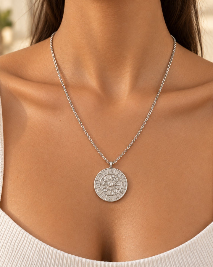 Elli Jewellery rhodium plated compass coin pendant necklace on a model, featuring a polished silver finish.
