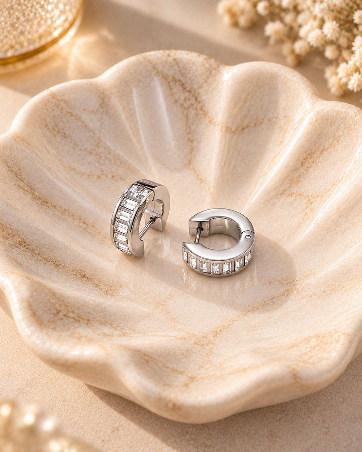 Elli Jewellery rhodium plated hoop earrings featuring baguette cut diamante stones in a decorative ceramic dish