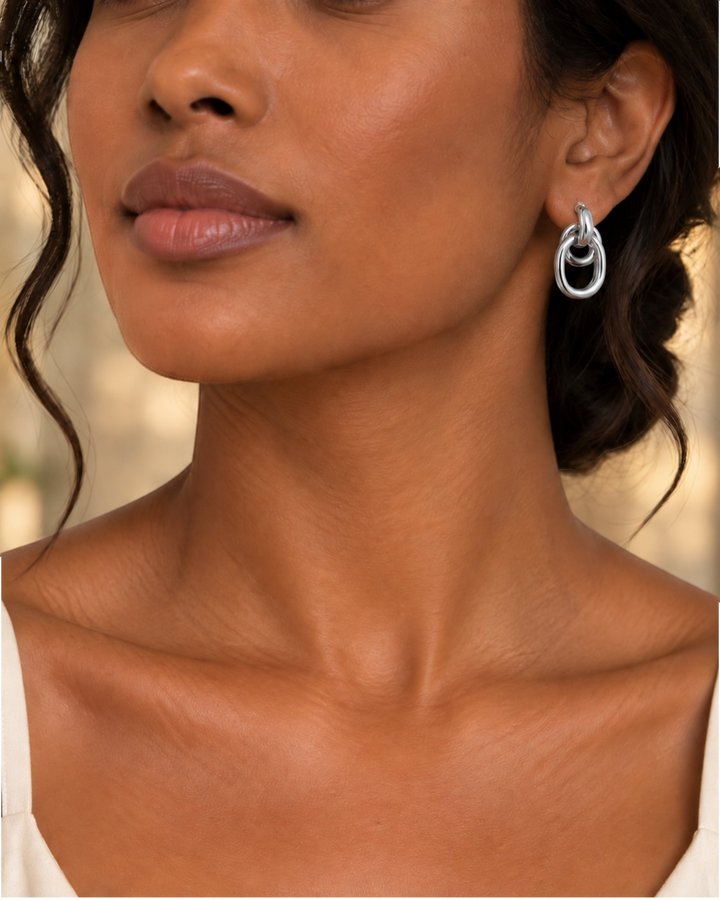 Elli Jewellery rhodium plated drop earrings featuring a sleek interlocking circle design worn by a woman