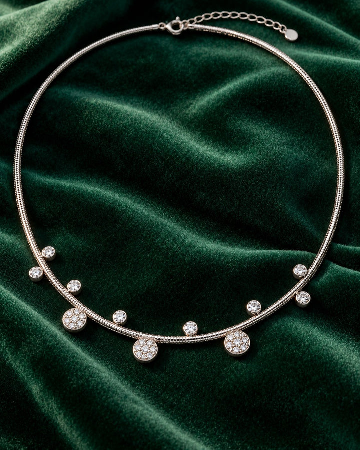 Elli Jewellery rhodium plated necklace featuring delicate circular floral charms with crystals on a green velvet base.